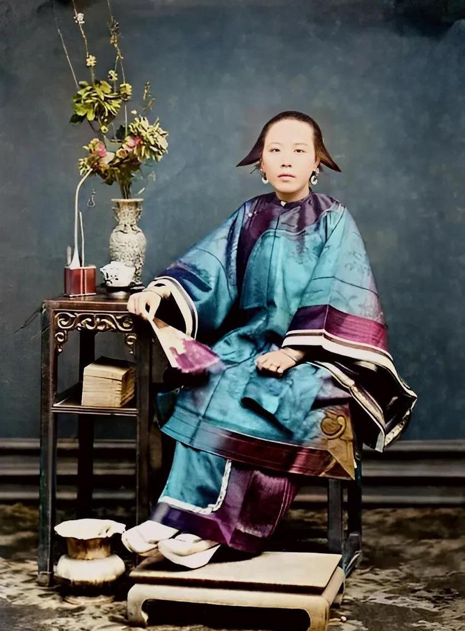 这是一位晚清时期衣装华丽的贵妇,她面容娇好,穿着宽袍大袖的袄裙