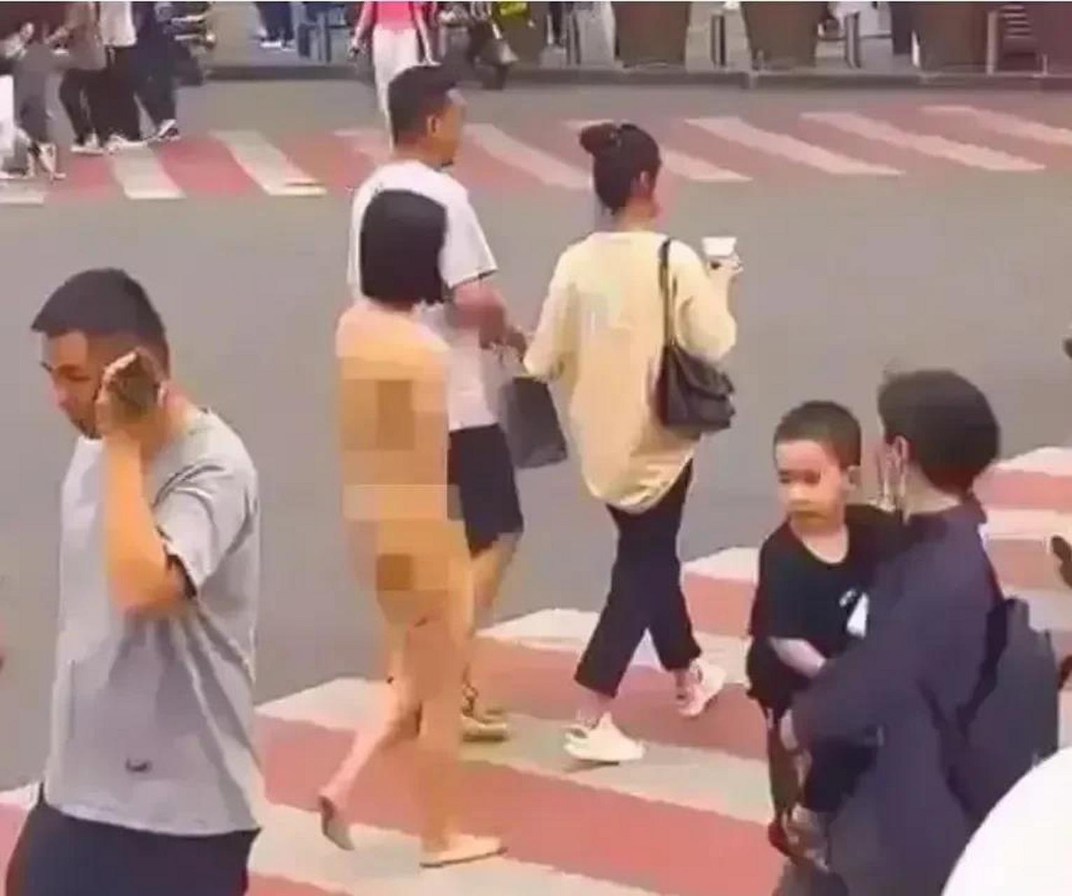 一女子"裸奔",一手提着内衣,一手拿着鞋子,众目睽睽之下光脚过马路,不