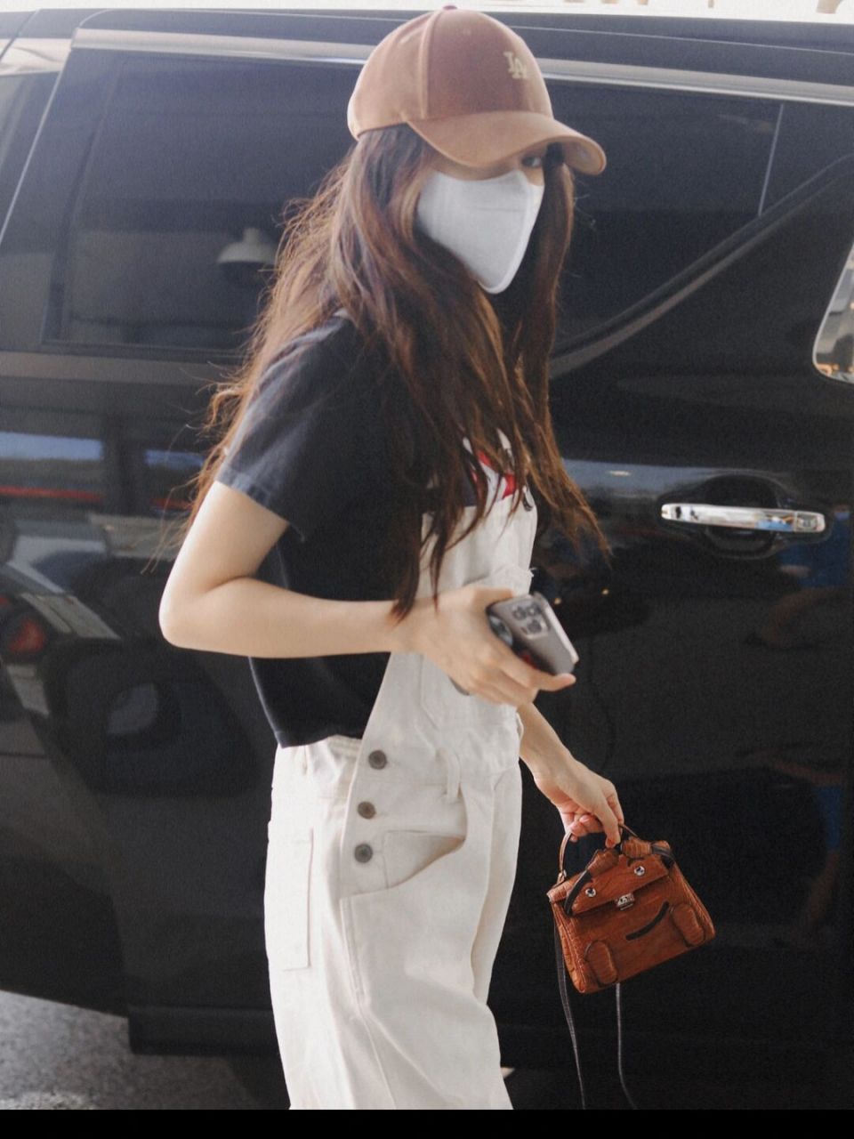 杨颖现身机场的私服穿搭 身穿复古卡通印花短袖t恤, 外搭白色背带牛仔