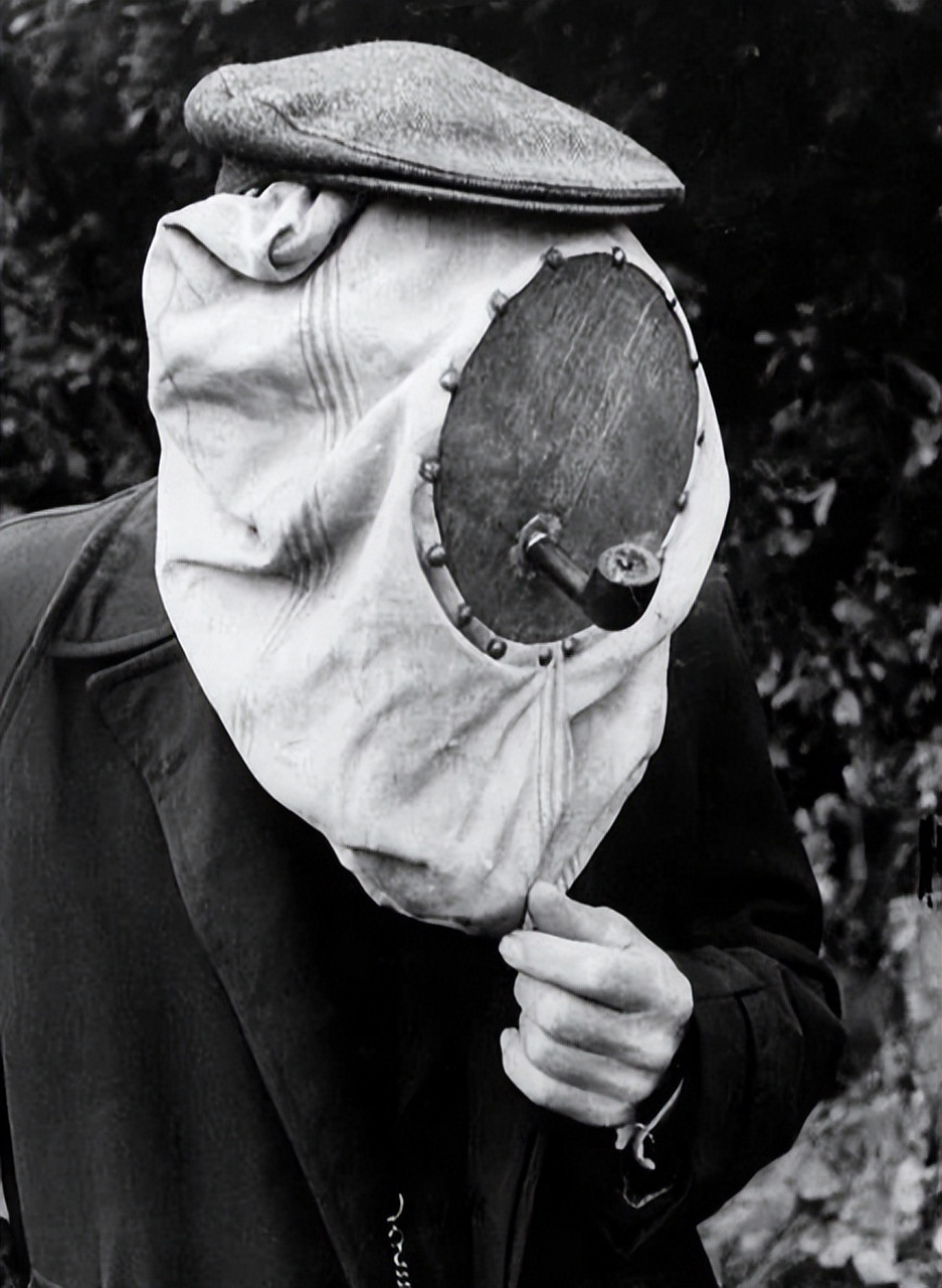 这位养蜂人,戴着面具,嘴里还叼着一个烟斗.