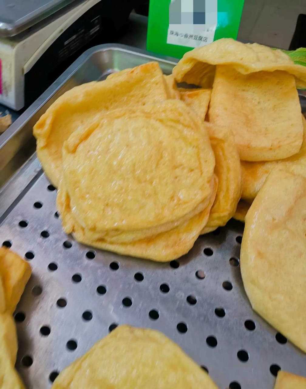 市场豆腐店刚出锅的炸豆腐皮,把炸好豆腐皮切成丝