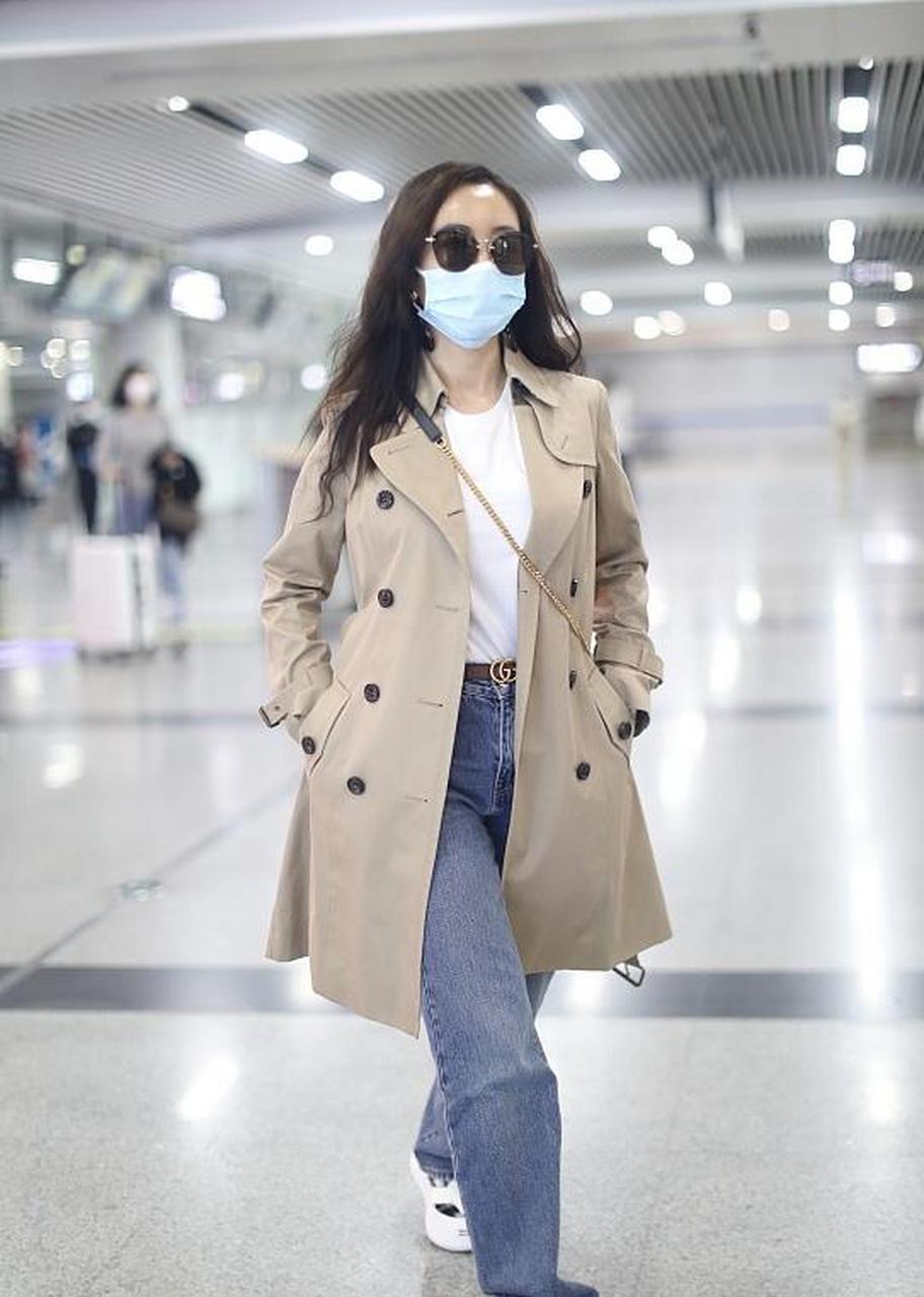 杨蓉街拍,她穿了一件卡其色的中长款风衣,内搭白色的圆领针织衫,搭配