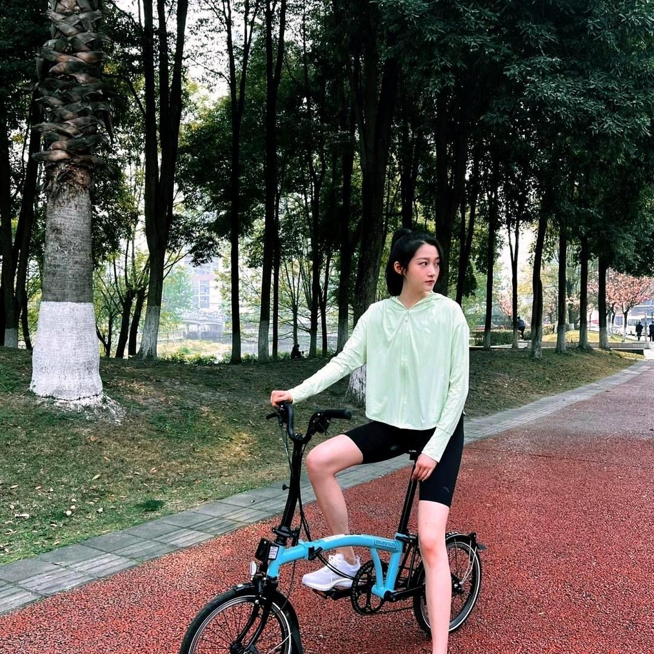 关晓彤在公园里骑车展现青春活力,她停下来拍照时,优美的长腿尽显魅力