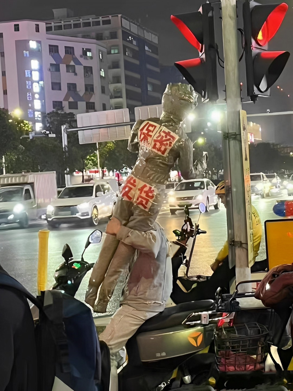 这组搞笑的照片中,一名快递员背着一个奥特曼人偶状的快递,外面包装纸