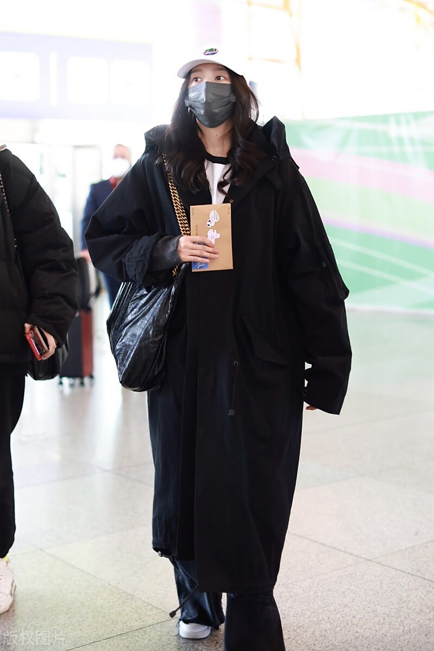 关晓彤机场街拍,黑色风衣搭配黑色阔腿裤,头戴白色棒球帽潇洒大方!