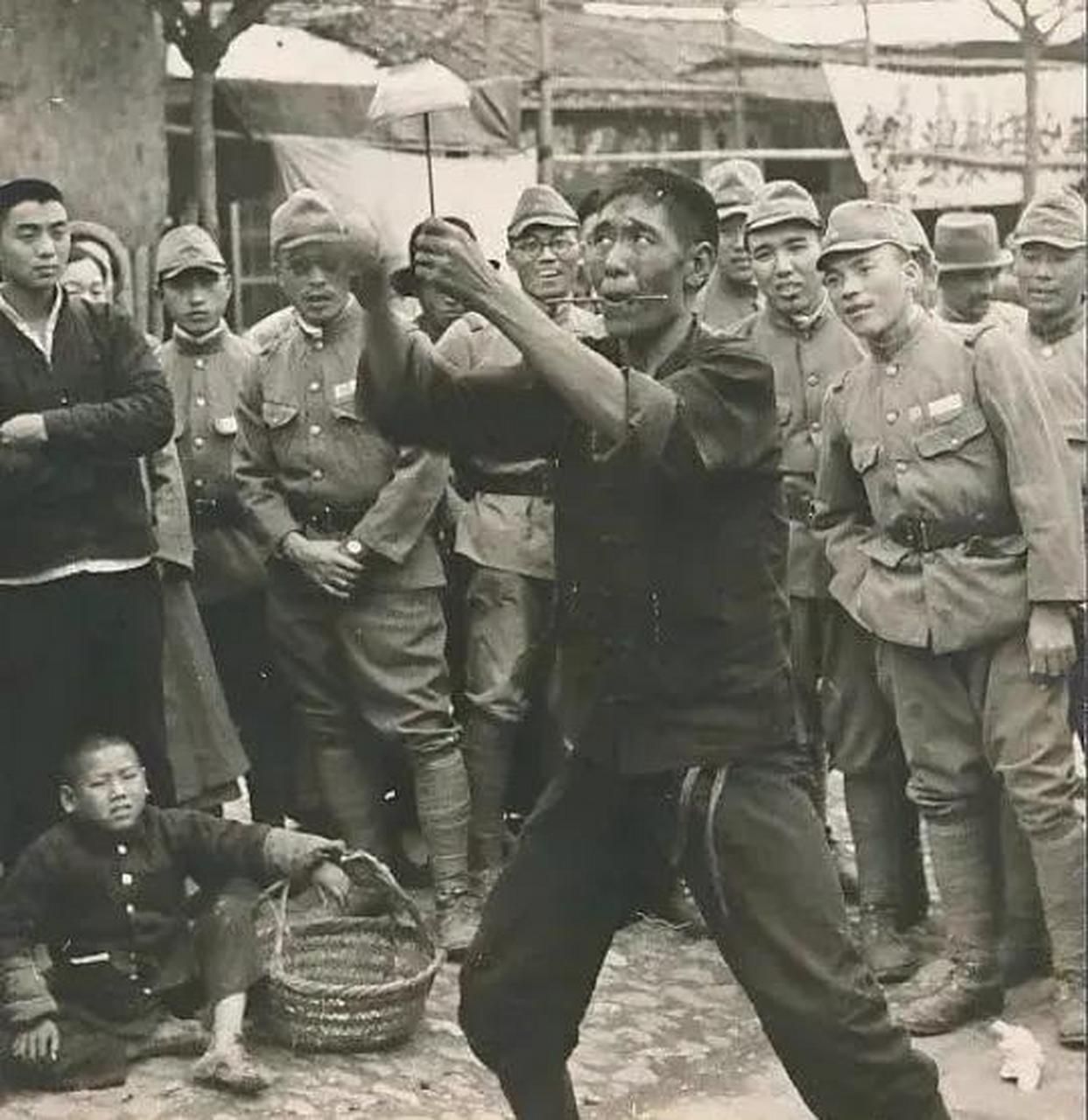 1941年的安徽合肥,一个小鬼子团队正在街头观看一位艺人表演"筷子顶碗