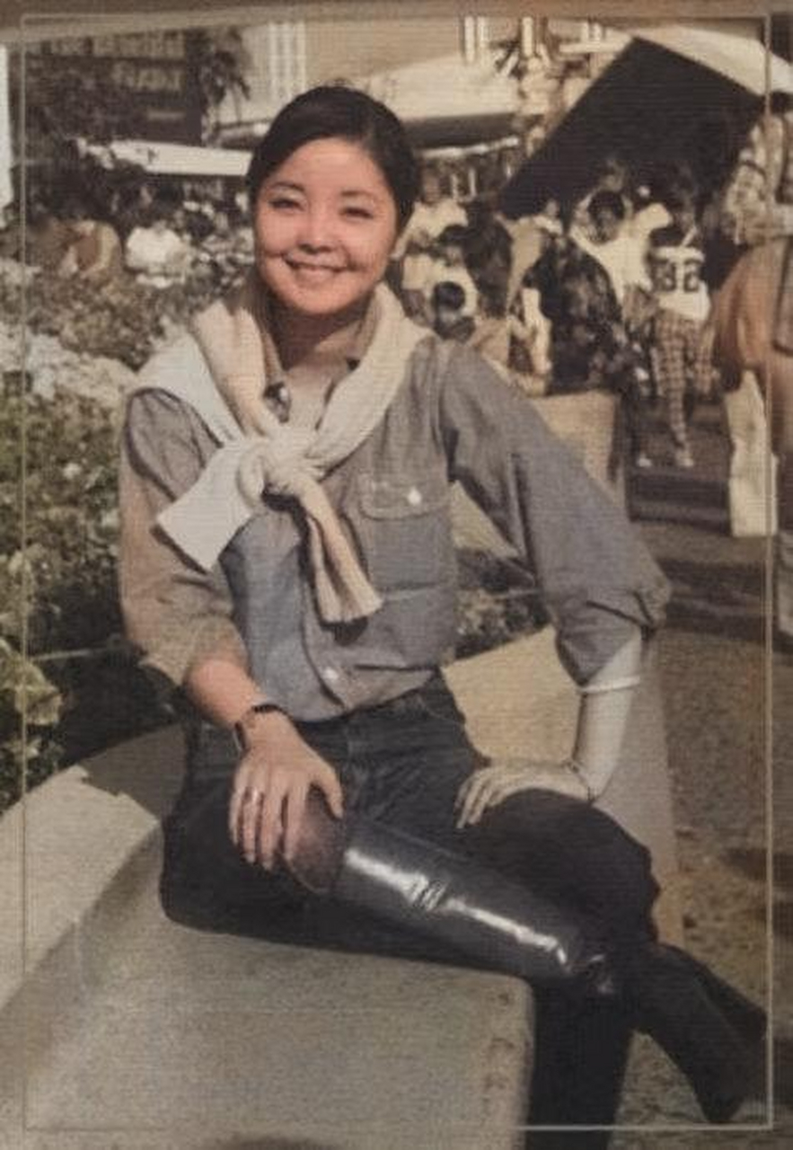 年轻时候的邓丽君在街边的甜美留影,照片中邓丽君穿着一件蓝色衬衫,一