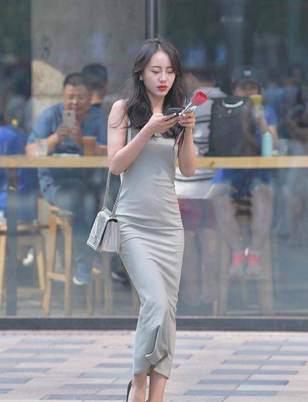 小妹妹一头长得飘逸的长发,加上手上拿着的红玫瑰,立刻突显了她的高贵