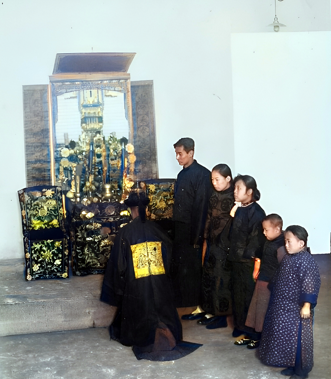 1915年,民国,一位身穿清朝官服的旗人在恭恭敬敬地插香祭拜.