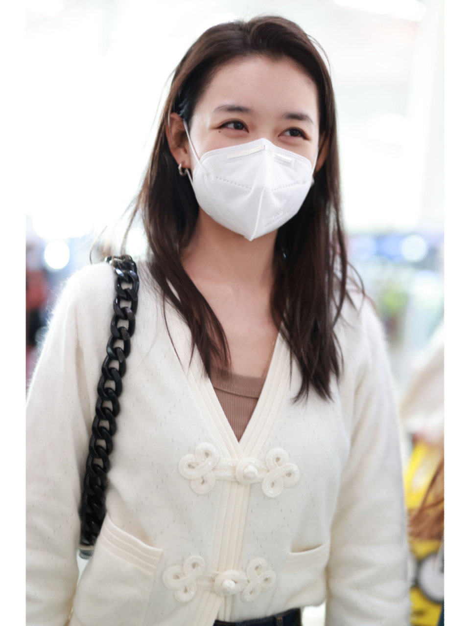 蒋依依素颜现身机场 身穿白色v领针织毛衣, 搭配吉祥结装饰微喇牛仔裤