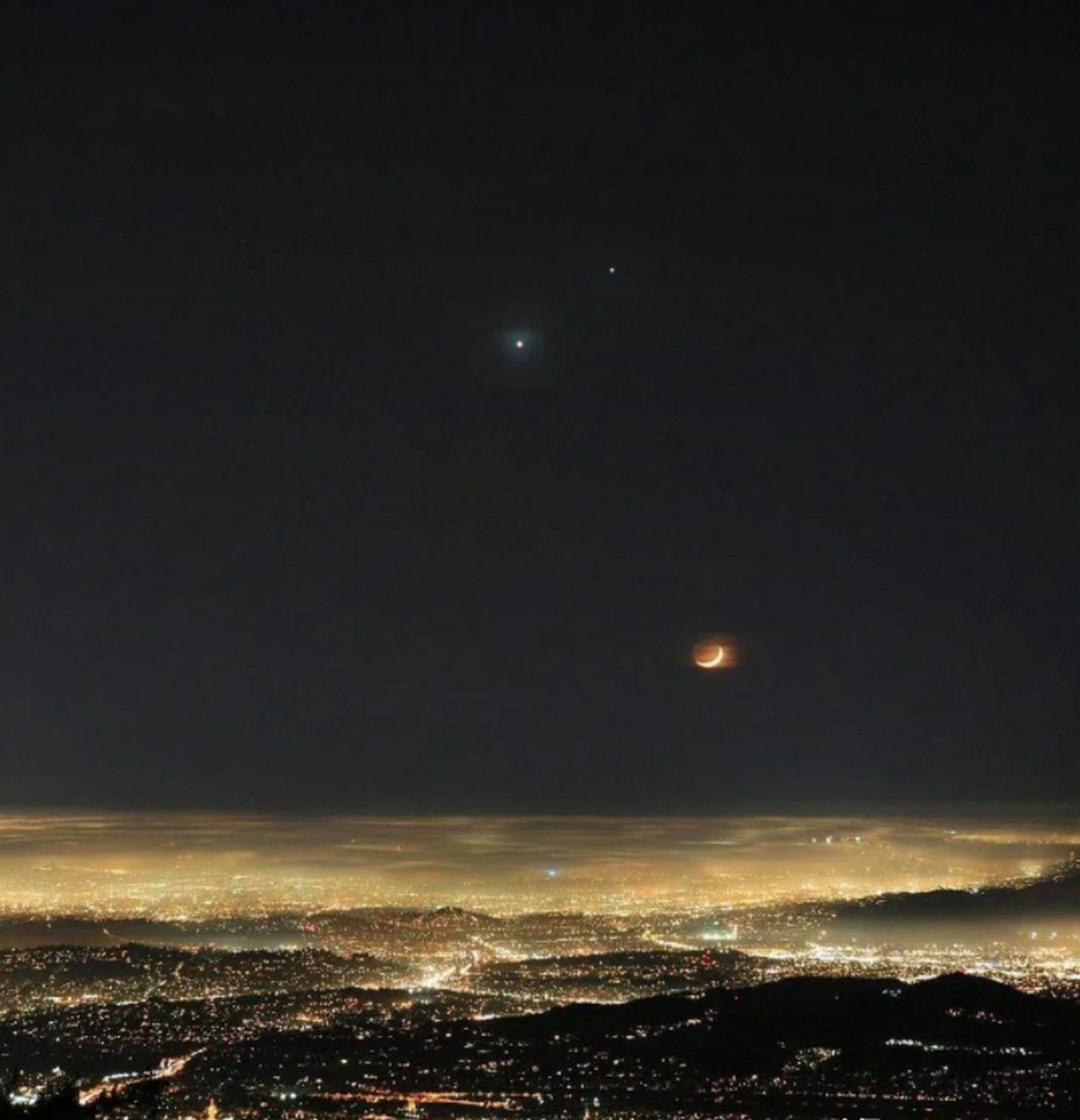 灯火辉煌的城市上空,月亮,金星和木星一起争辉!