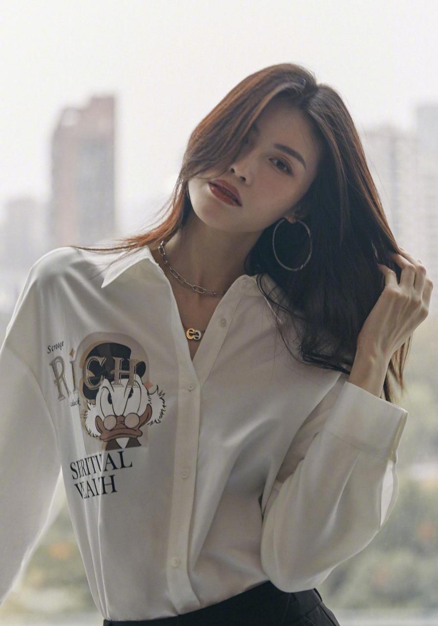 何穗和大衣真的是绝配 黑色羊毛大衣内搭唐老鸭印花衬衫,加上利落长靴
