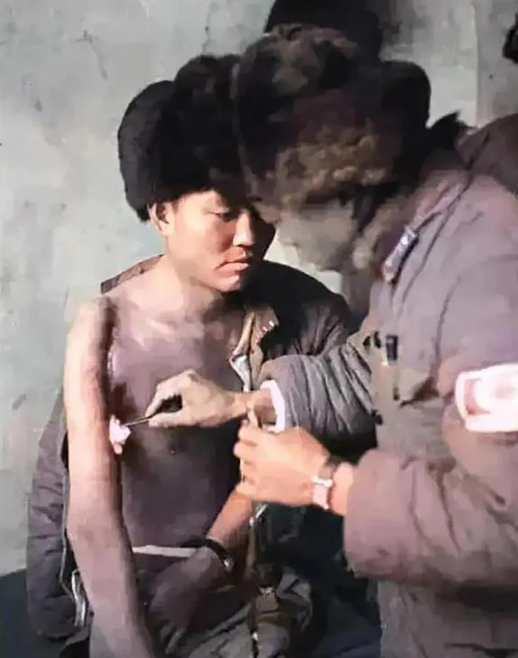 1936年,绥远抗战前线,一名护士正在小心翼翼的给伤员处理伤口,伤员的