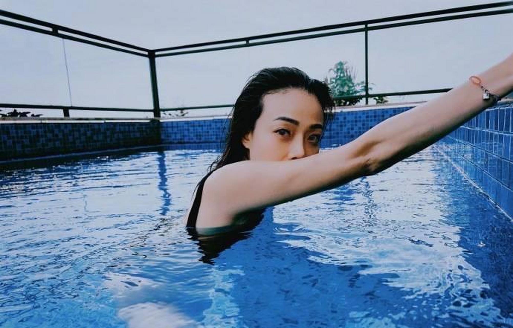 容祖儿晒泳池照穿露背泳衣,开心玩水激起片片水花.