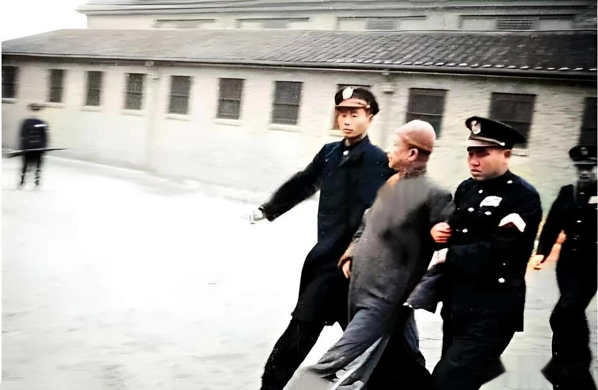 1947年在南京的老虎桥监狱里面拍摄的照片,照片中被警察押着的男子叫