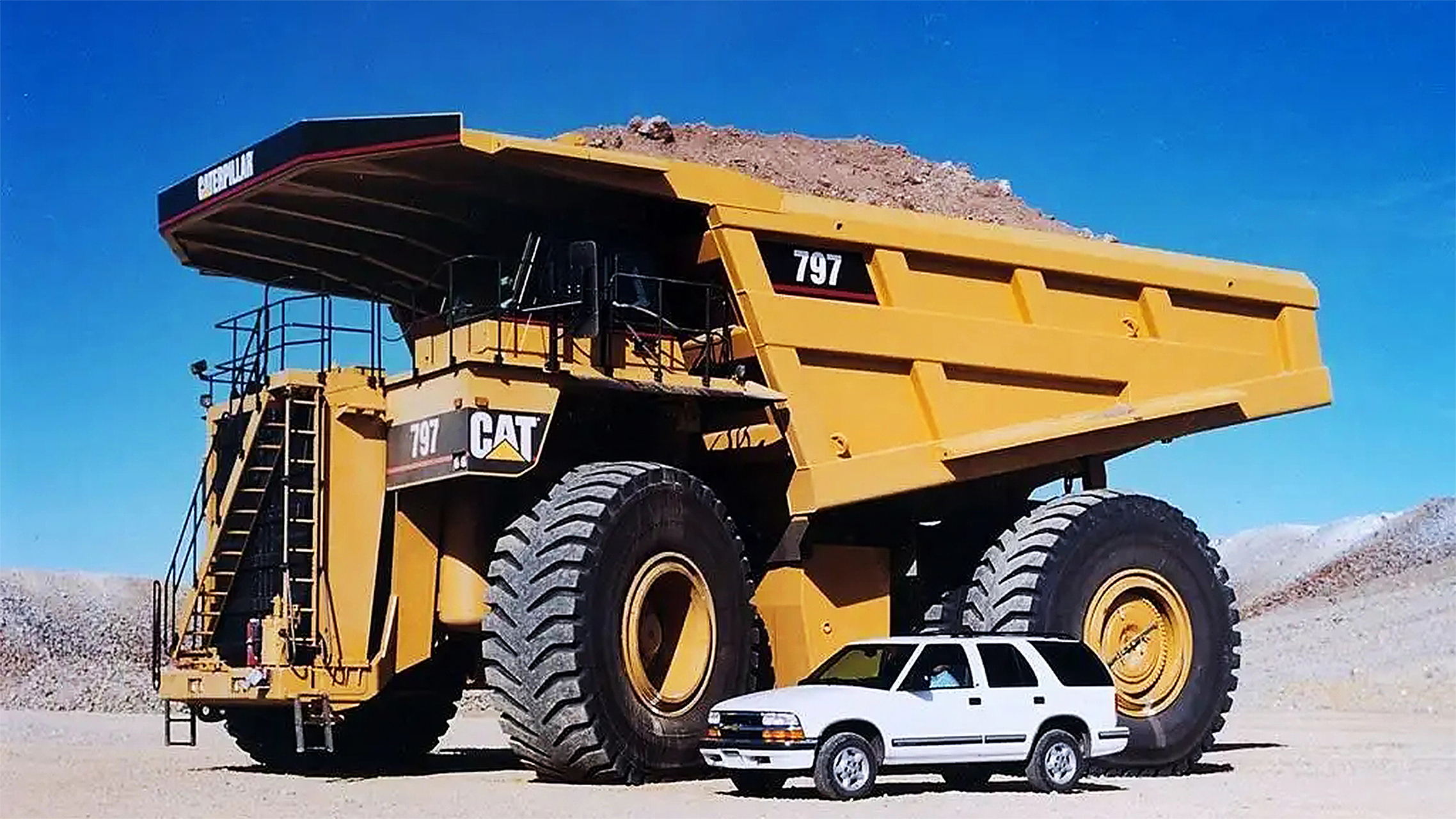 这是一台巨大的卡特彼勒797b,在她身上的一切都是超级大,车高超过了七