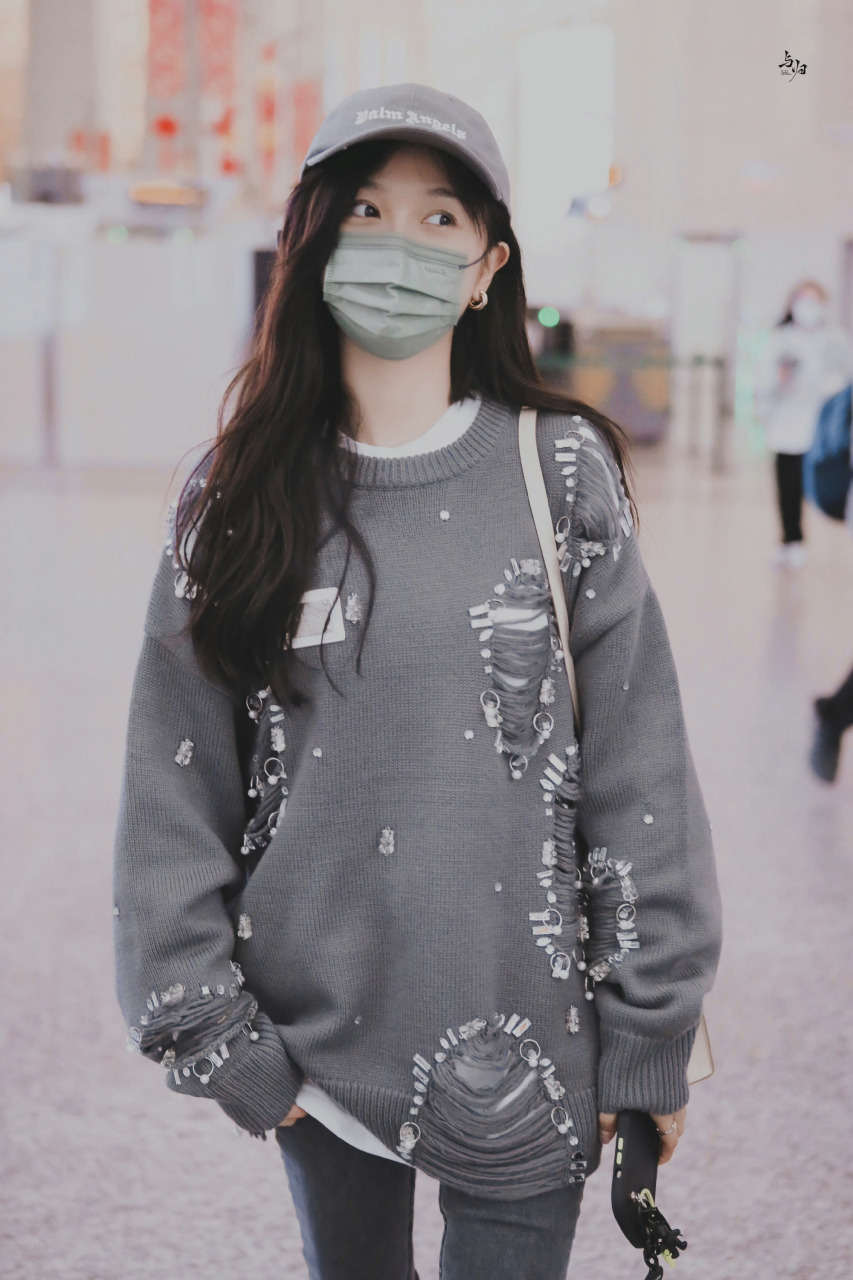 吴宣仪机场街拍 灰色破坏钉钻毛衣搭同色系鸭舌帽,深灰色牛仔裤配白色