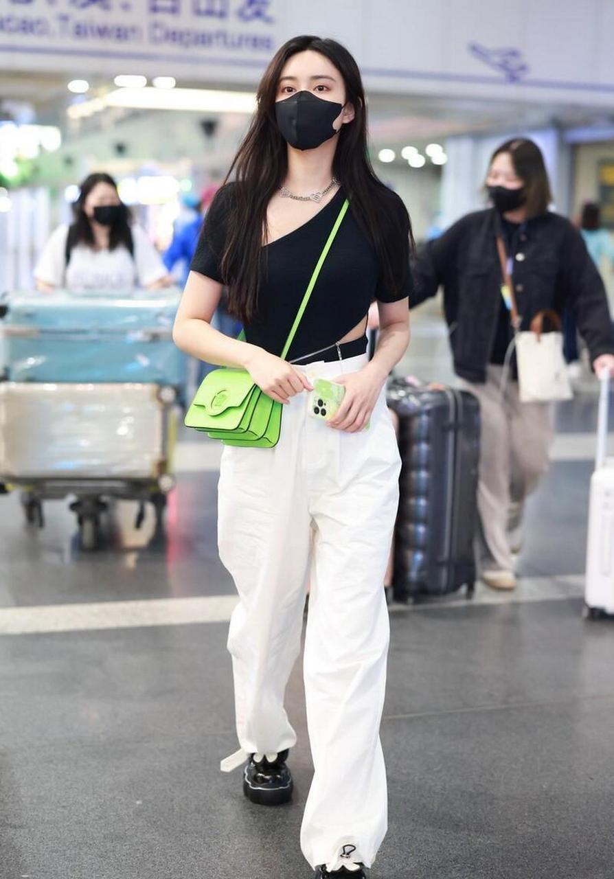 孟子义机场街拍,黑色挖空上衣 白色休闲裤versace绿色手袋简约时尚