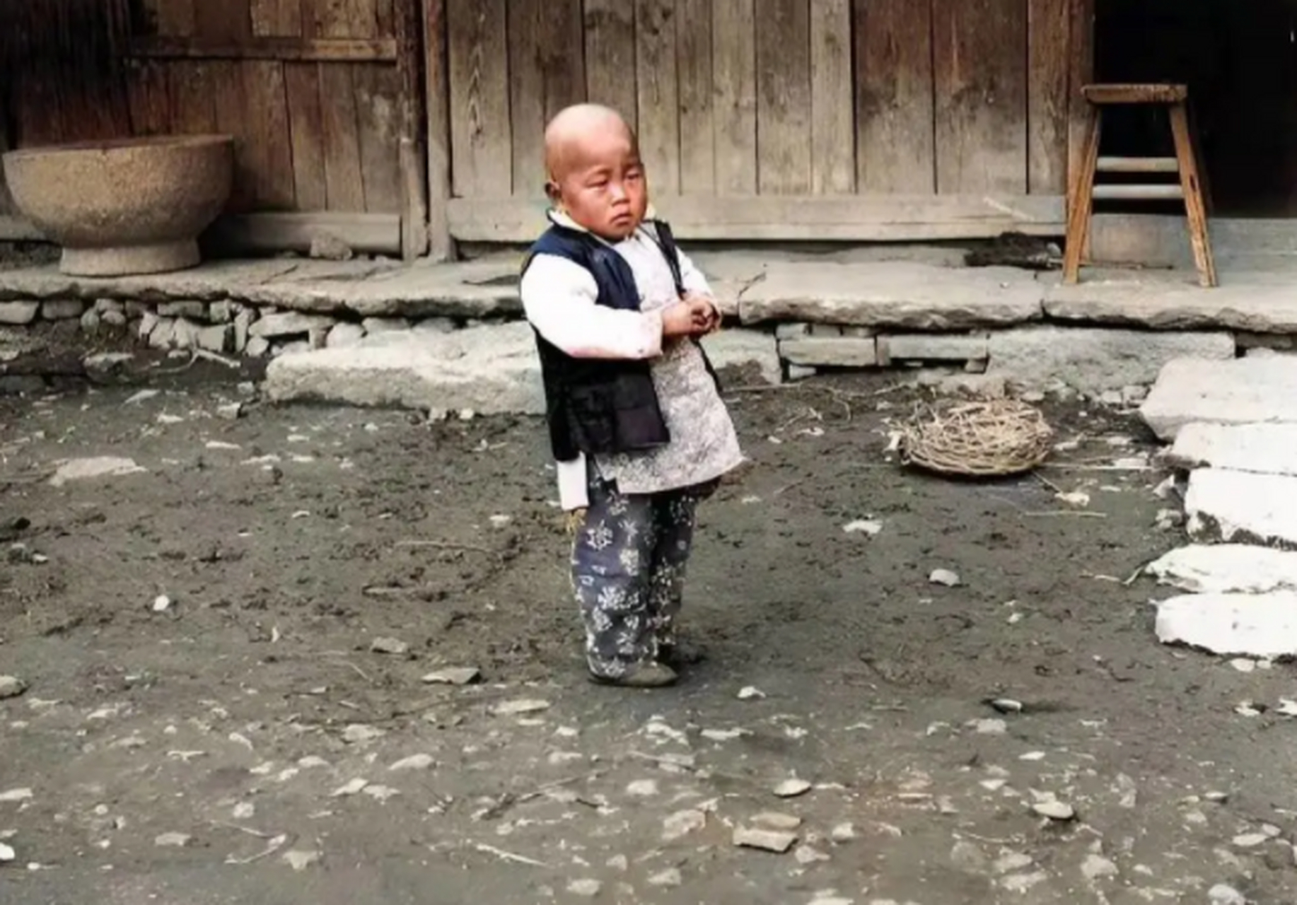 清朝老照片:在一个农家小院拍摄的照片,一个小孩子正独自在院中玩耍