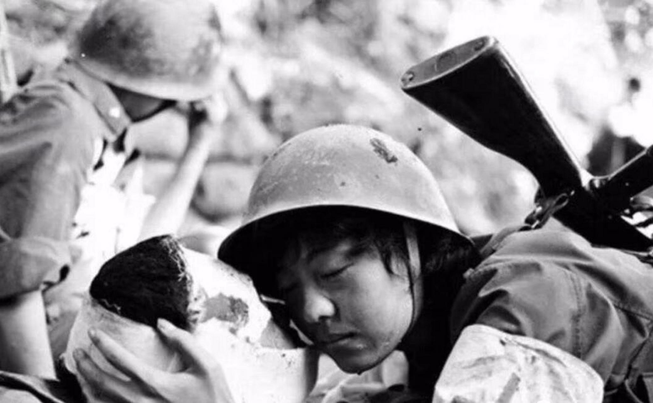 老山前线一所简陋的战地医院里,护士张茹拥抱着重伤的战士,轻吻战士的