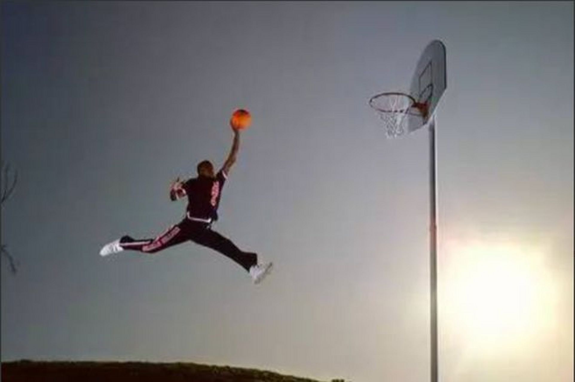 照片中的乔丹单手托球,身体完美挺直,飞跃在半空中,准备将篮球投进