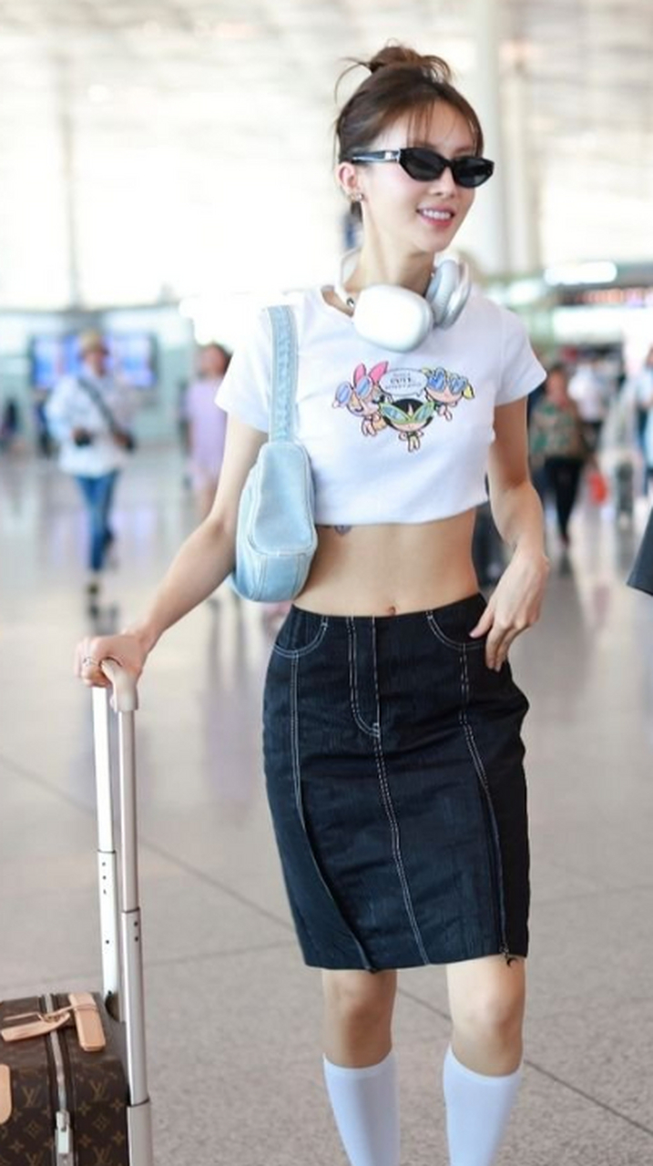 金晨戴耳机墨镜现身机场 穿露脐装大秀马甲线.