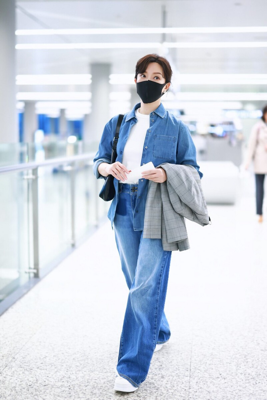 陈数机场随拍,牛仔衬衫内搭白色t恤,搭配阔腿裤和白色运动鞋,低调大气