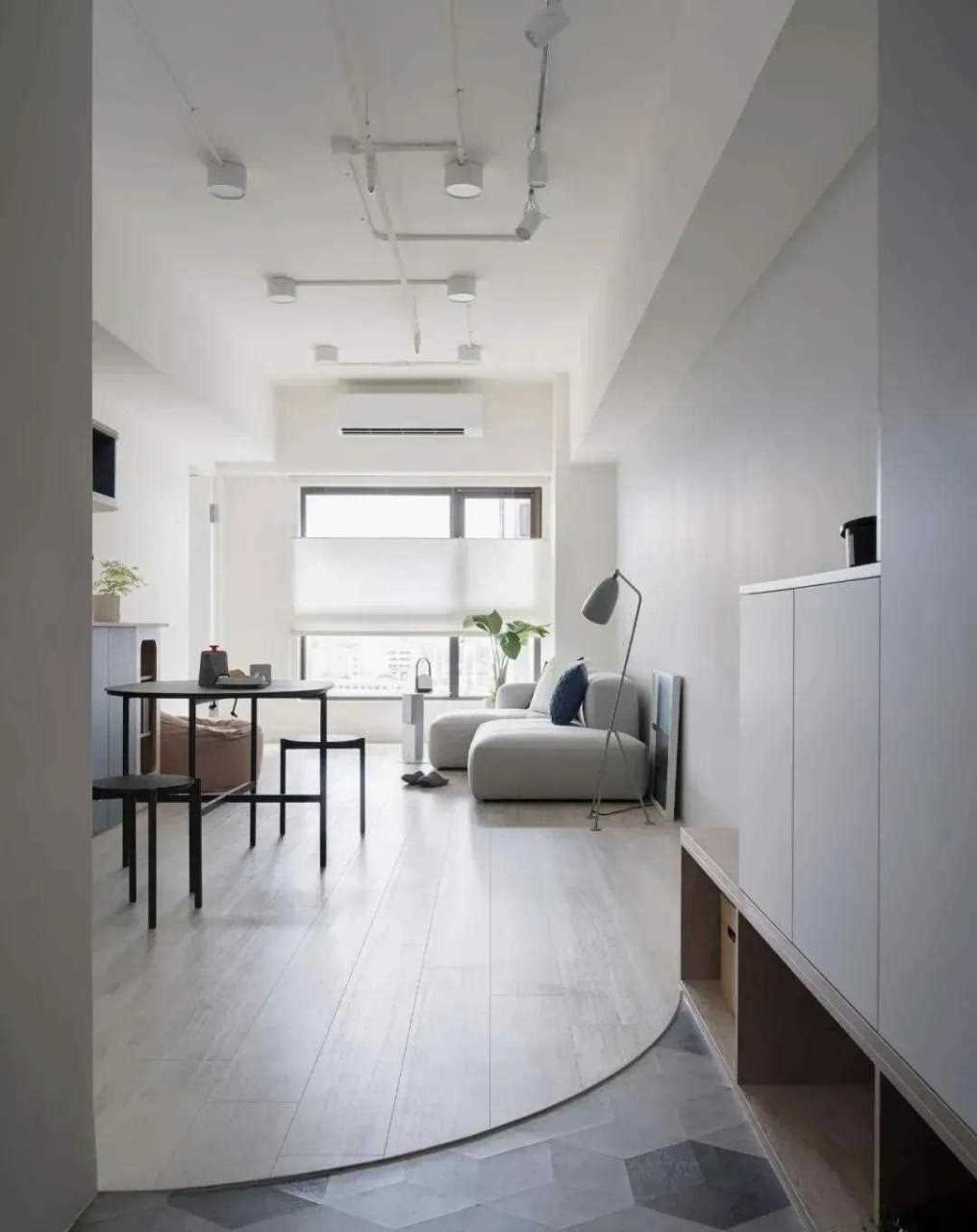 【现代风格装修案例】客餐厅的木地板与玄关处设计了一个高低落差来