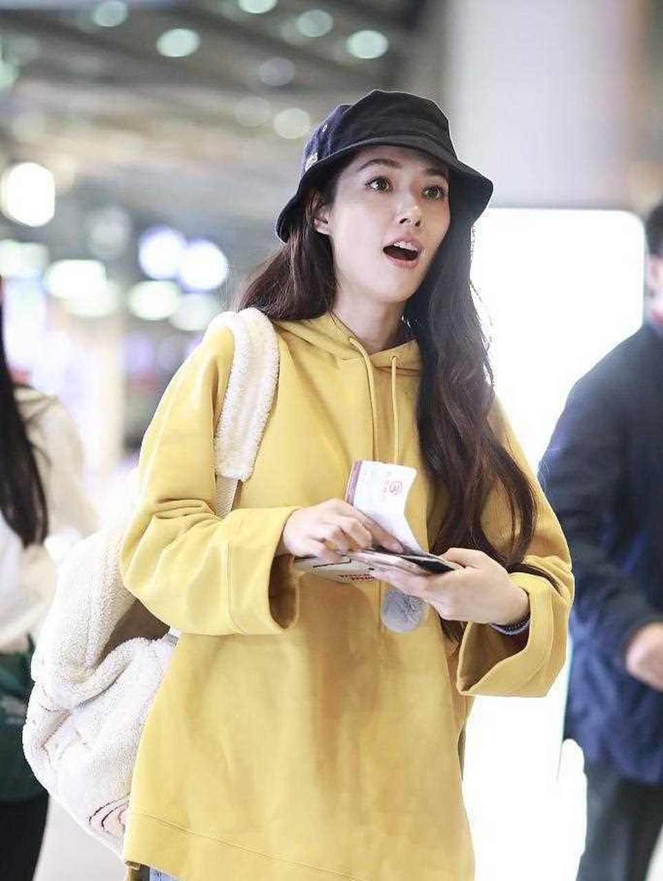 郭碧婷近日机场私服,黄色宽松卫衣配浅蓝色阔腿牛仔裤,搭配黑色渔夫帽