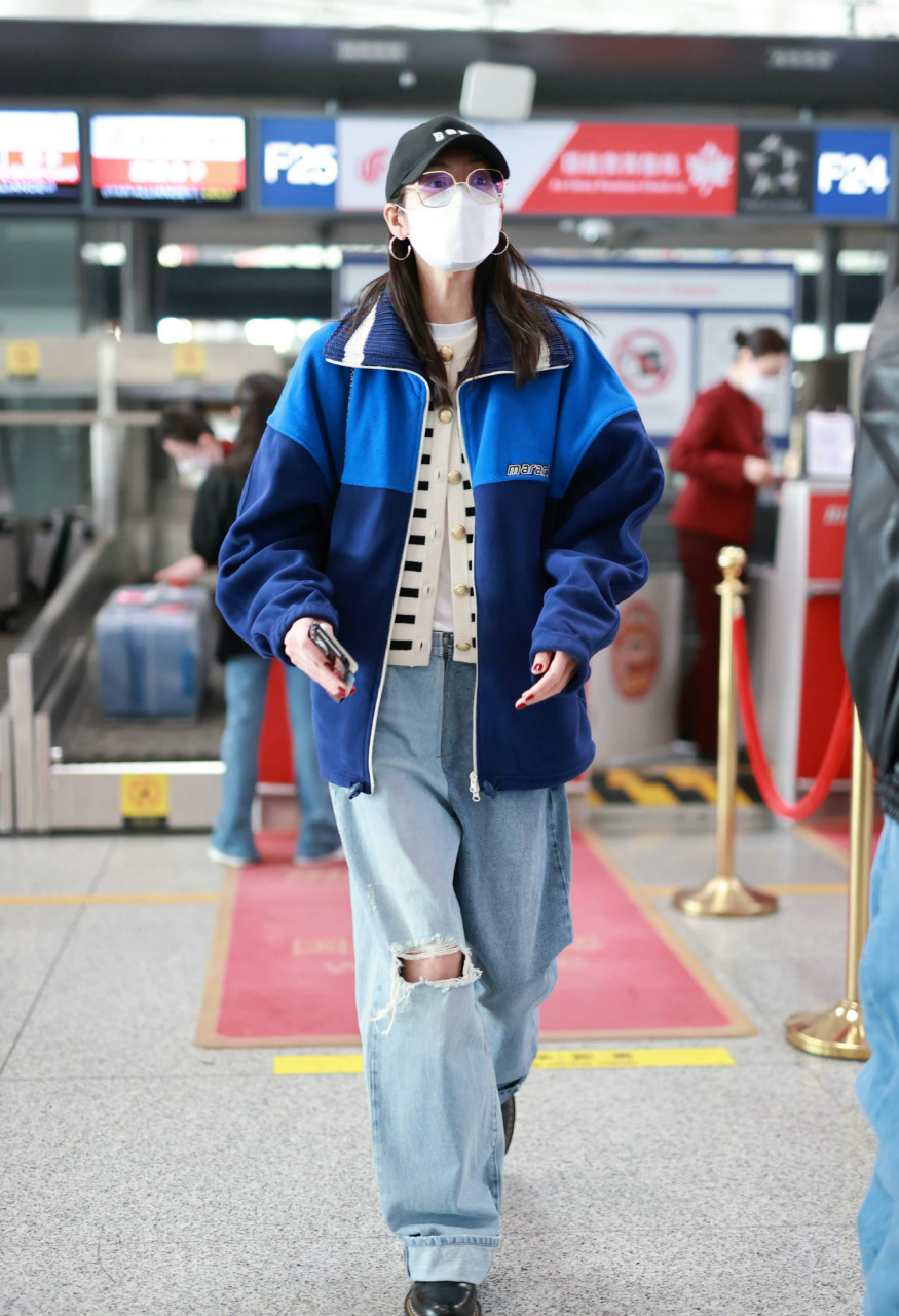 刘雯机场街拍,身穿蓝色拼色抓绒夹克,内搭条纹羊绒衫,下身破洞牛仔裤