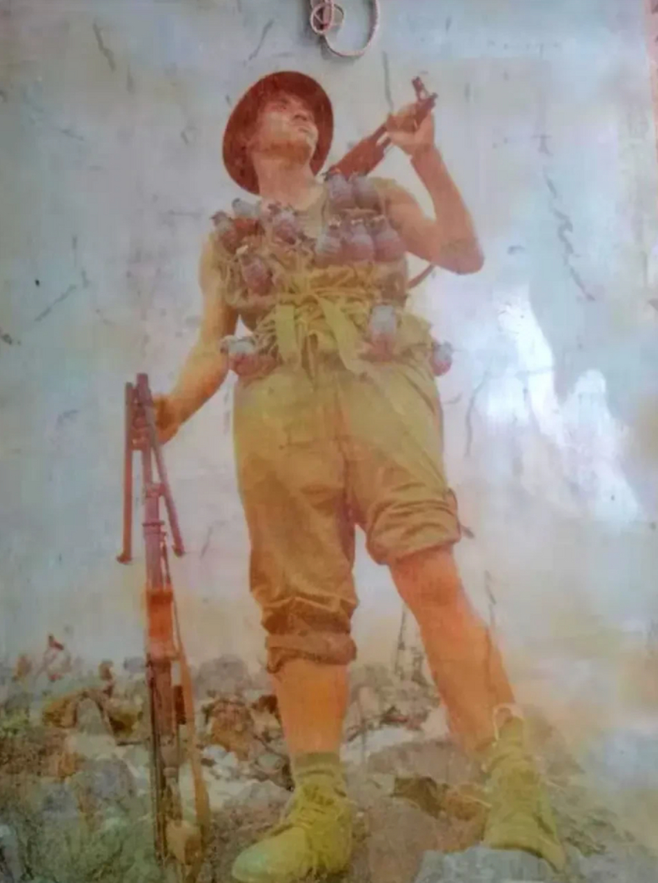 照片中的英雄名叫马信武,他肩扛冲锋枪,身上挂满了