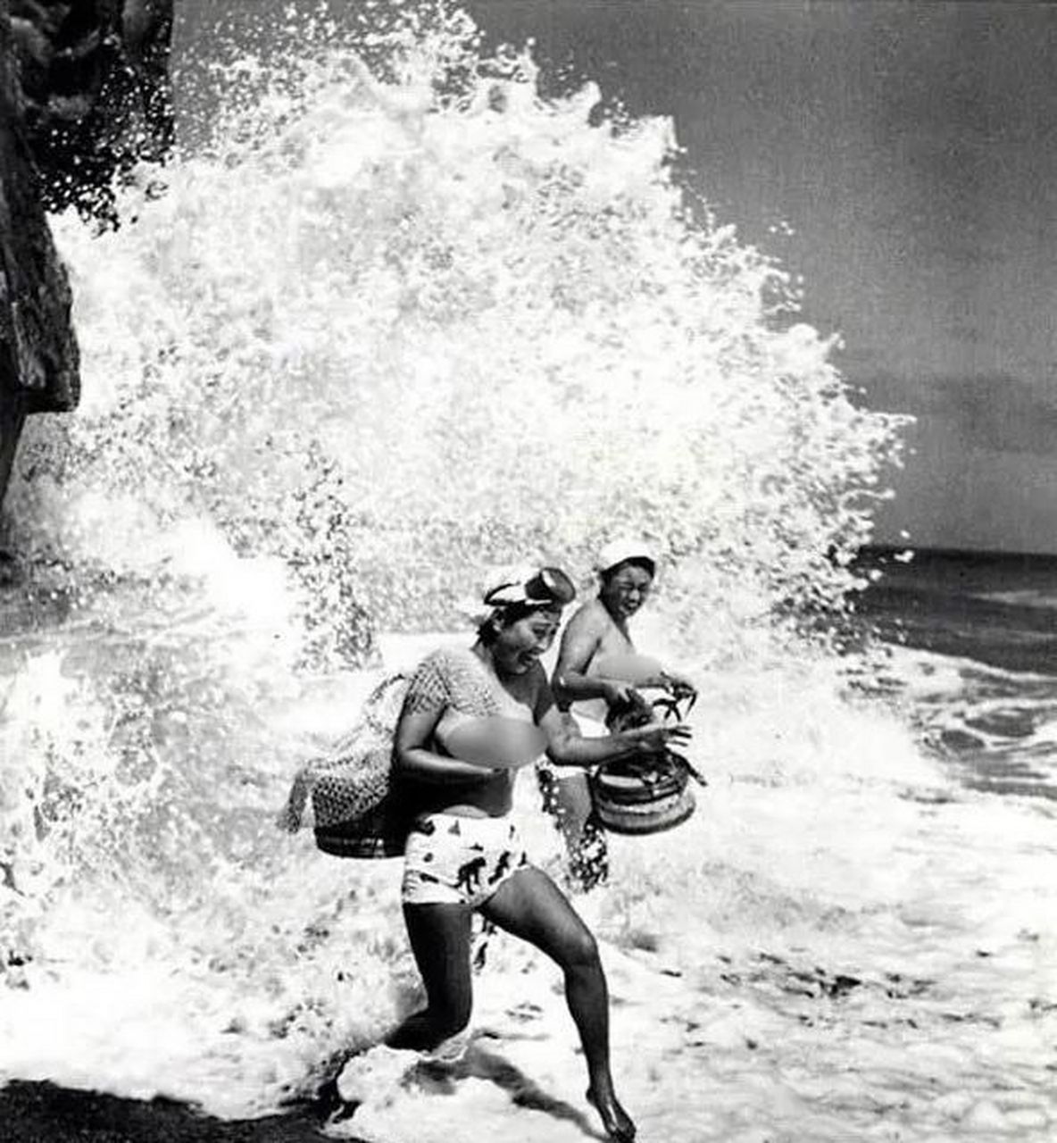 二十世纪初,二名日本海女在海浪拍打的岩石边,快步跑过.