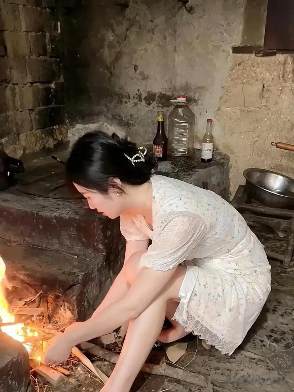 照片中这个女人真漂亮,在农村的厨房里忙忙碌碌,正在烧火做饭.