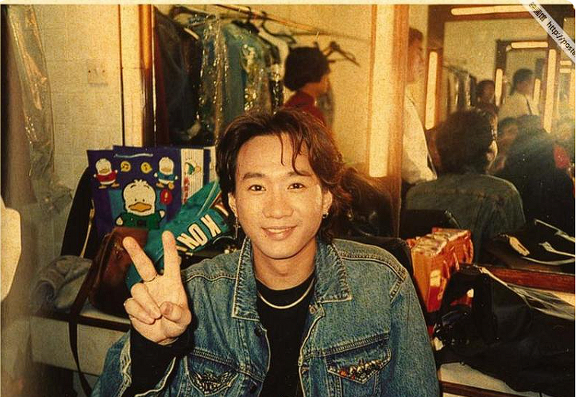 照片中的黄家驹留着一头乌黑的长发,一身挺拔的军装.