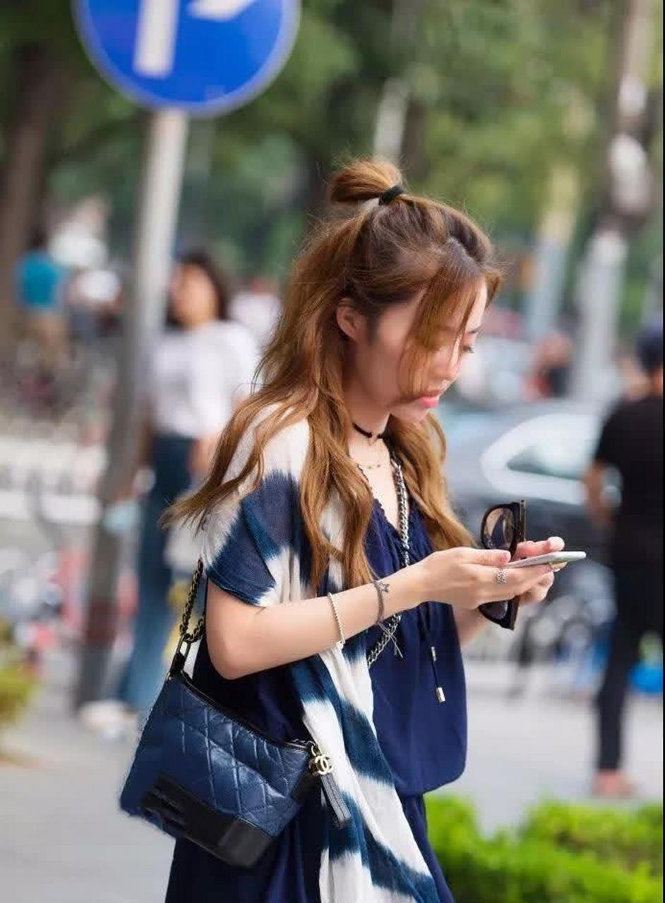街拍:丸子头时髦波浪卷发的性感美眉,蓝色短裙身段好穿搭时尚!