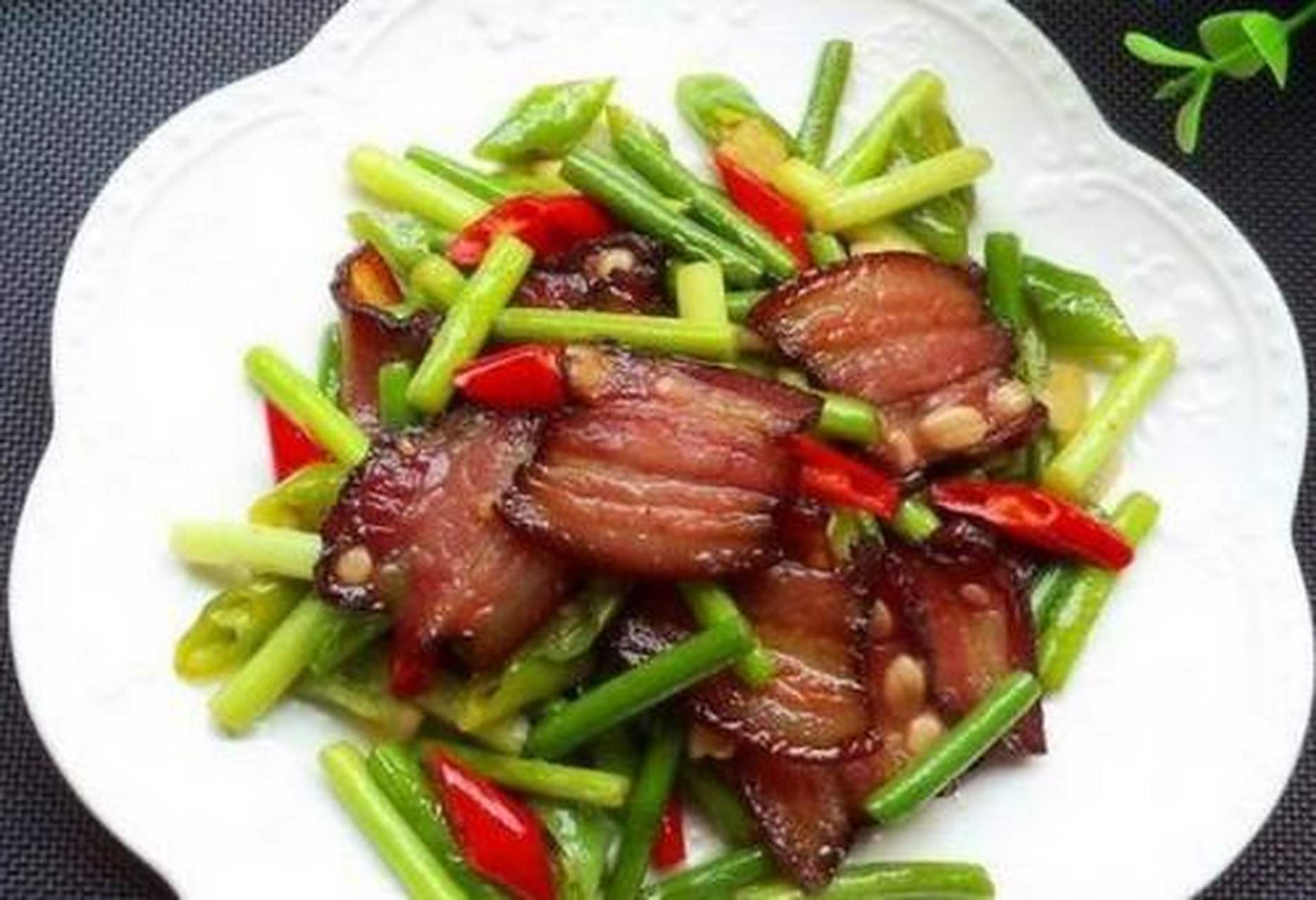 蒜薹掐掉头,尾,用清水洗净,切段,腊肉用淘洗水浸泡片刻,洗净;腊肉皮用