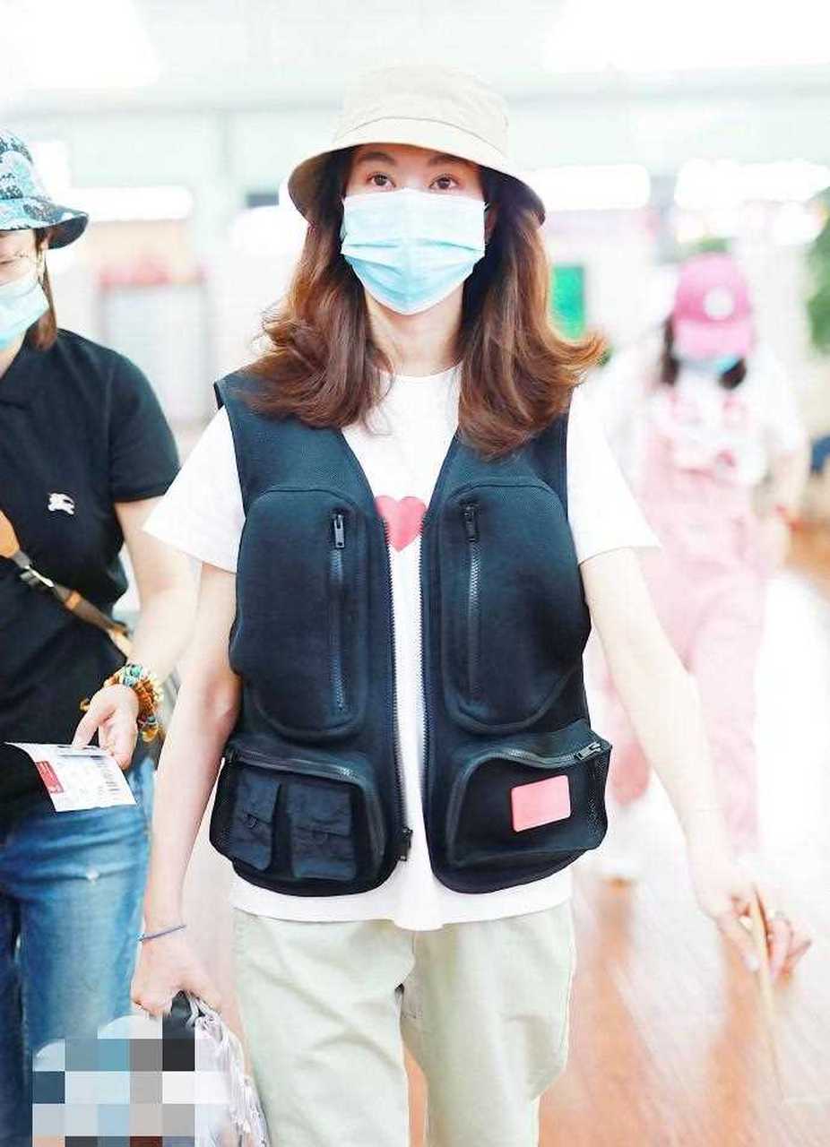 郁可唯最新机场私服,白色t恤搭配工装风马甲帅气舒适,绿色裤子和帽子