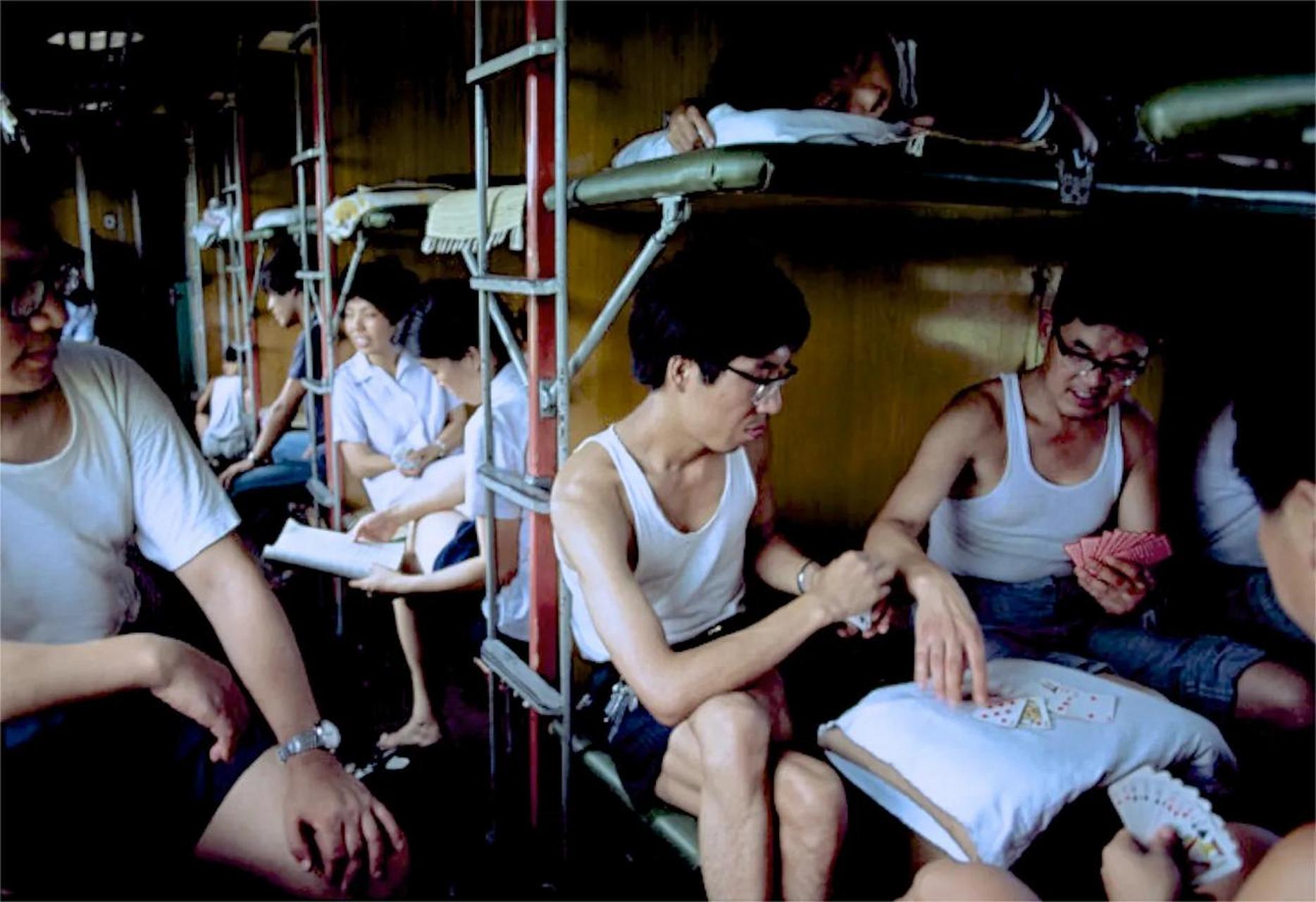 在1979年,一辆绿皮火车上的旅客们都坐在硬卧车厢里,或打牌,或聊天