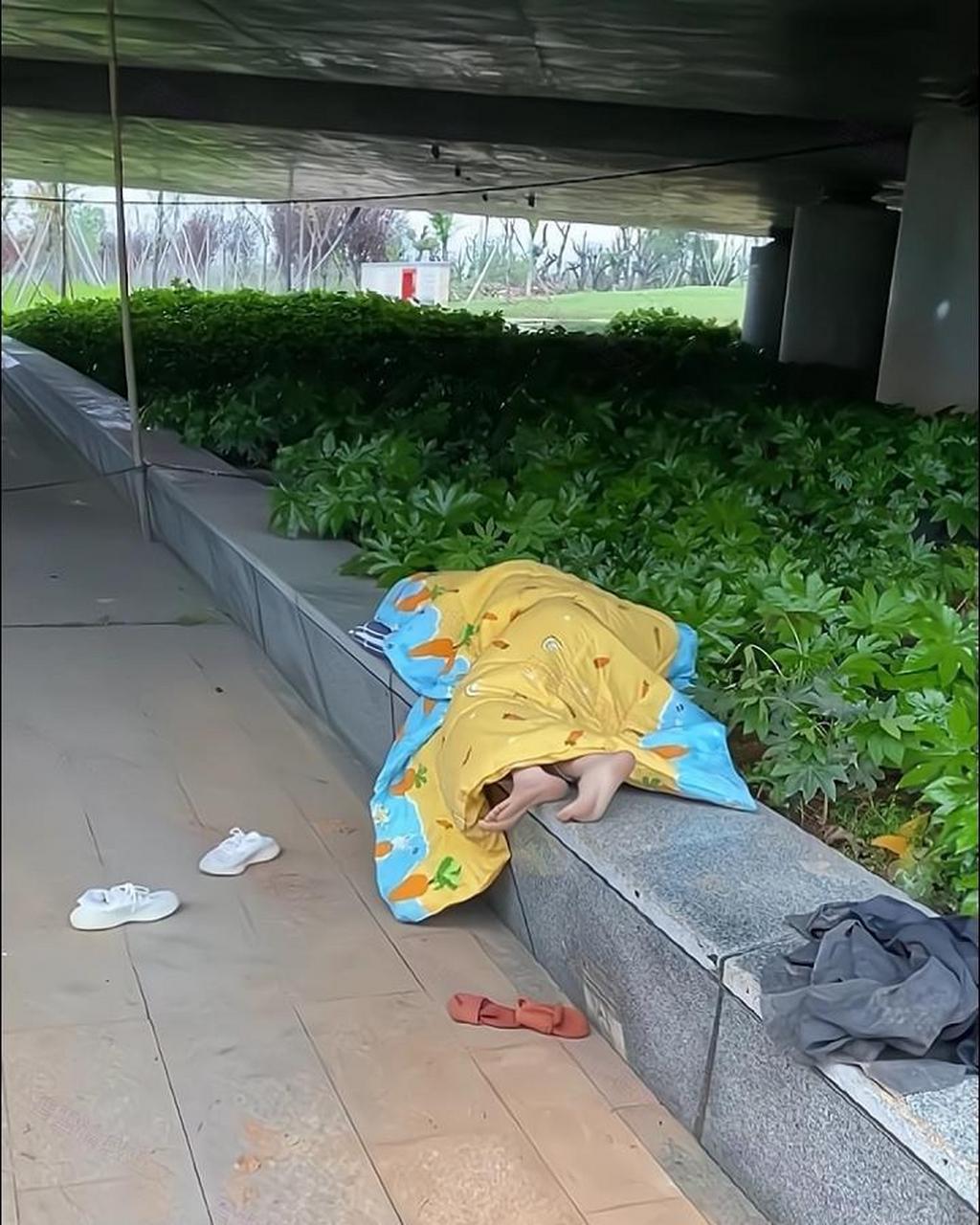 早上看到一名女子睡在桥洞下面,她看到有人经过后,光着脚抱着被子就走