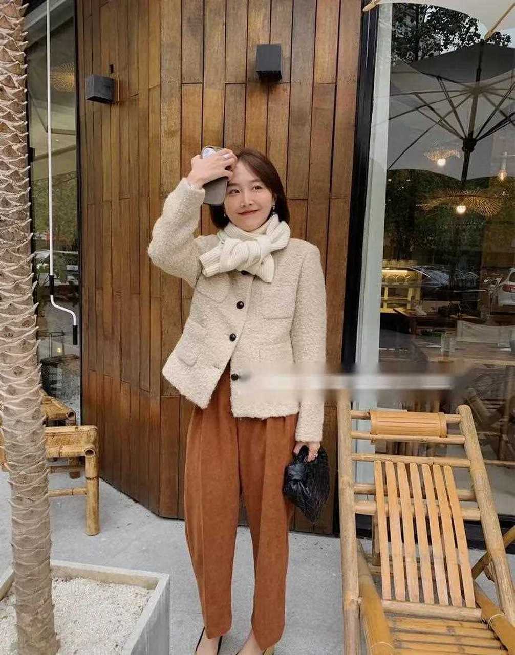 脏橘色裤子是整套穿搭的点睛之笔,与杏色羊毛上衣搭配在一起温柔又