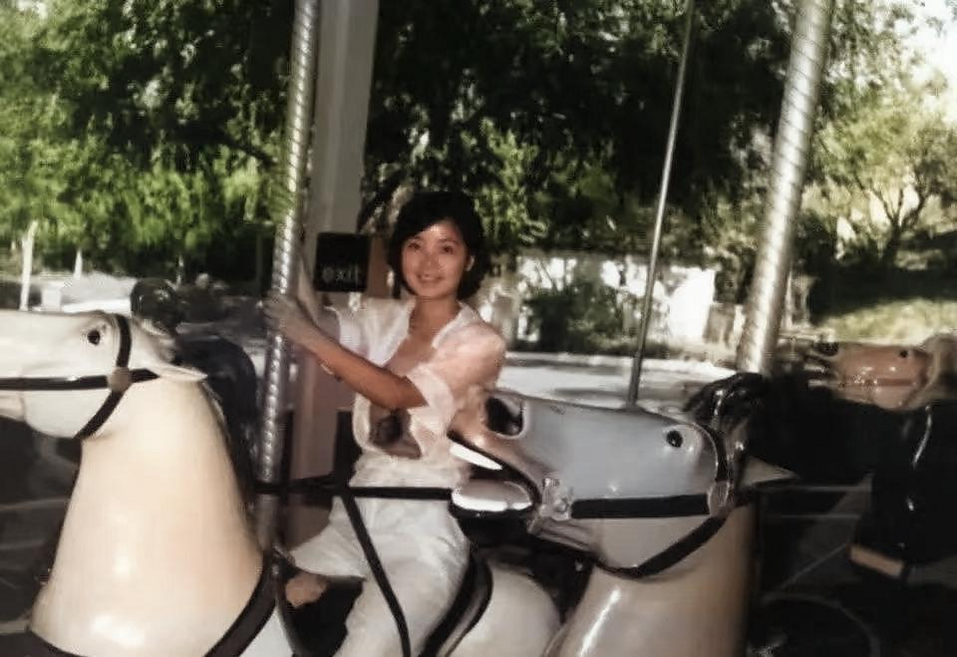 80年代,邓丽君在美国洛杉矶公园里游玩时的留影,照片中邓丽君坐在旋转