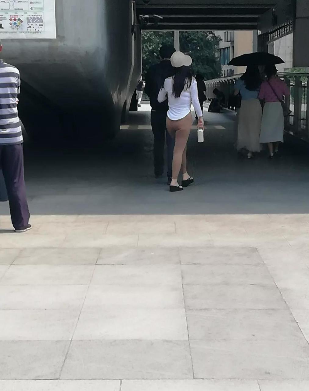 一位女士穿着很薄的紧身裤从旁边走过,都勒出了一条缝,回头率杆杠的