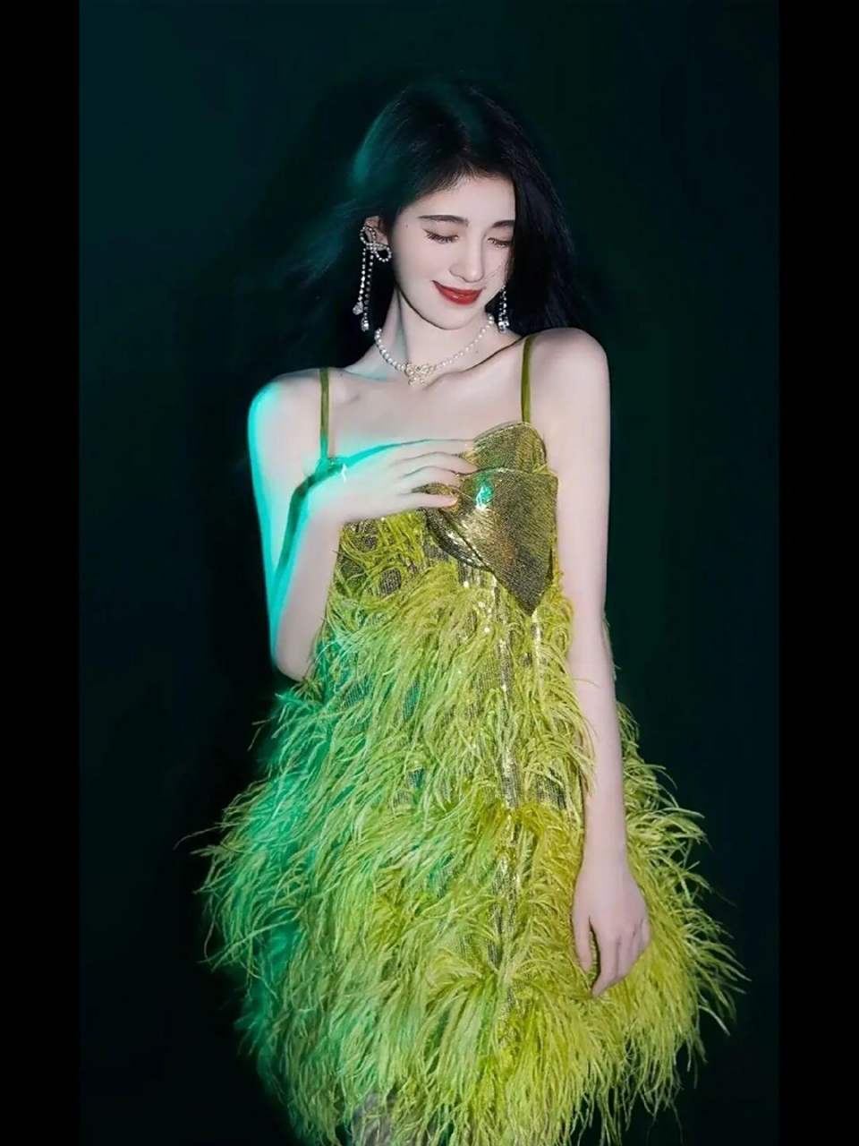 鞠婧祎的气质真的是绝了,穿着一条绿色的羽毛吊带连衣裙,清新浪漫
