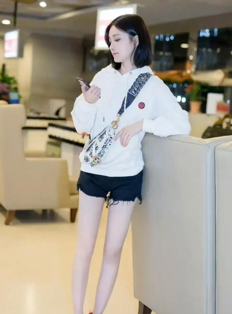 孟子义身穿白色连帽运动卫衣搭配黑色牛仔短裤和红色运动鞋,元气吸睛