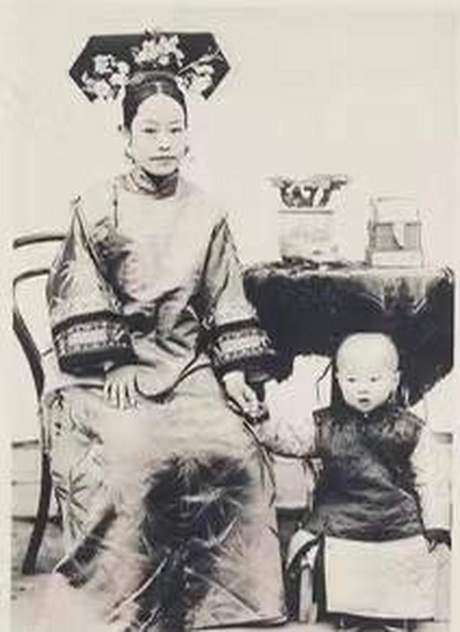 这张拍摄于清朝末年的照片中的女子名为叶赫那拉静荣,她的丈夫是镇国
