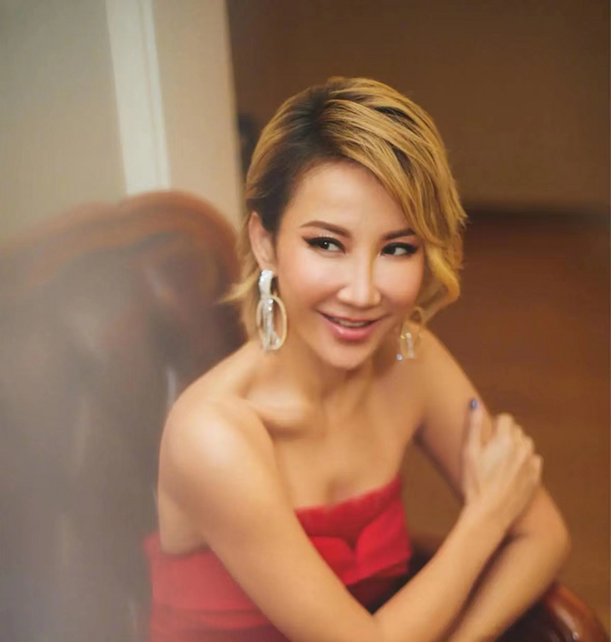 照片中李玟的化妆非常大胆.她穿着一件带有透视效果的白色薄纱上衣.