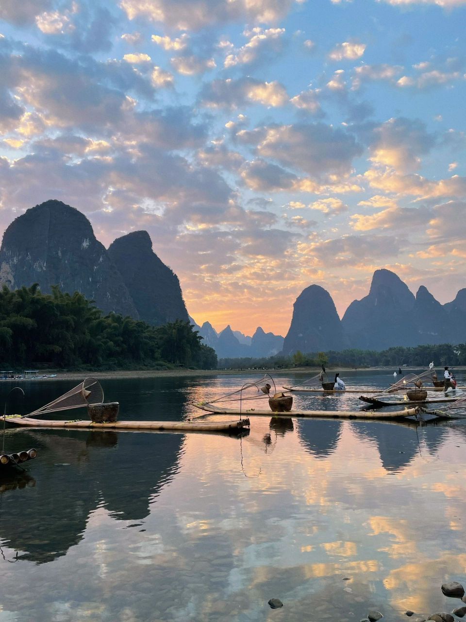 夕阳落山霞满天,映得漓江美如画. 碧水静照千峰翠,鸬鹚渔人自悠闲.