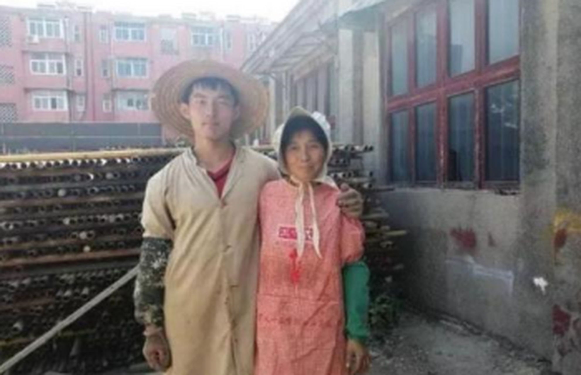 烈日炎炎下,19岁的林万东在工地上辛苦背200斤沙子.