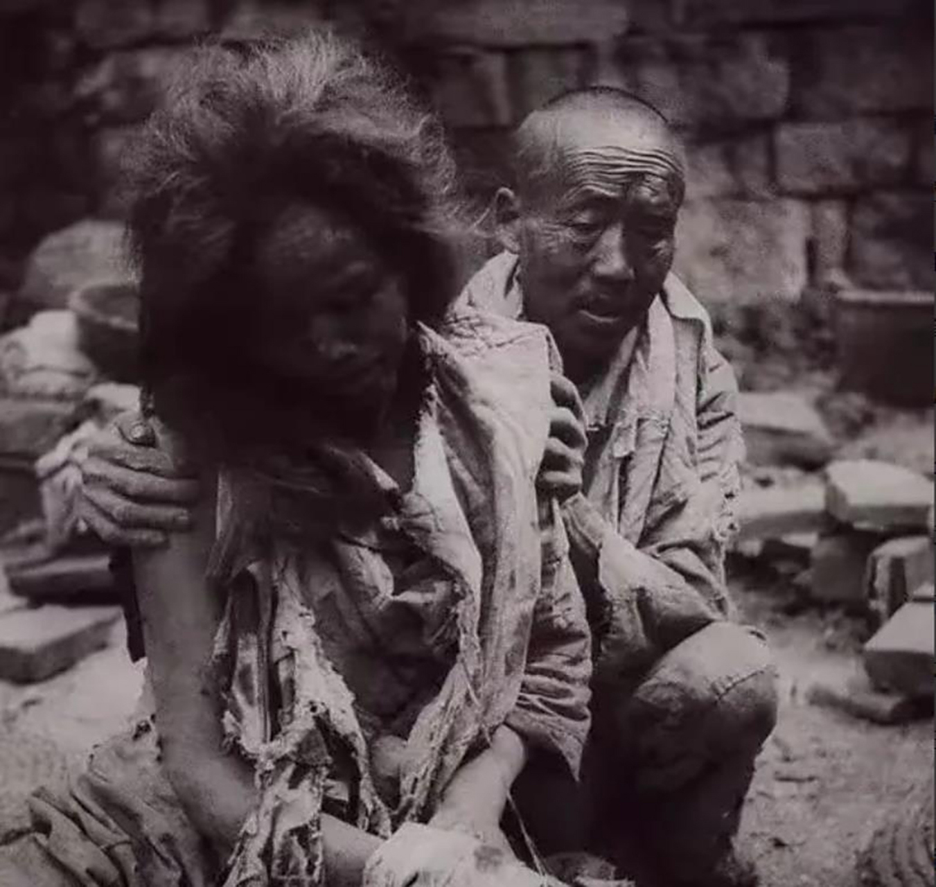 照片中的女子,被折磨得几乎不成人形,全身伤痕累累,她的背后是一个