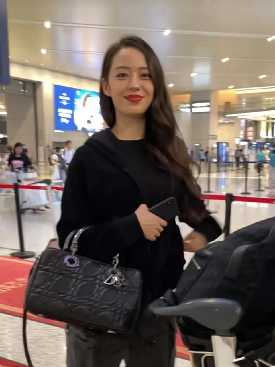 郎朗妻子吉娜的机场照曝光,三伏天气,她上身穿黑色长袖外套,搭了一条